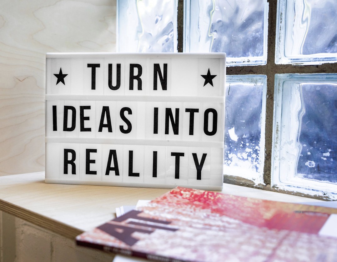 A lightbox sign reading 'Turn ideas into reality' on a windowsill